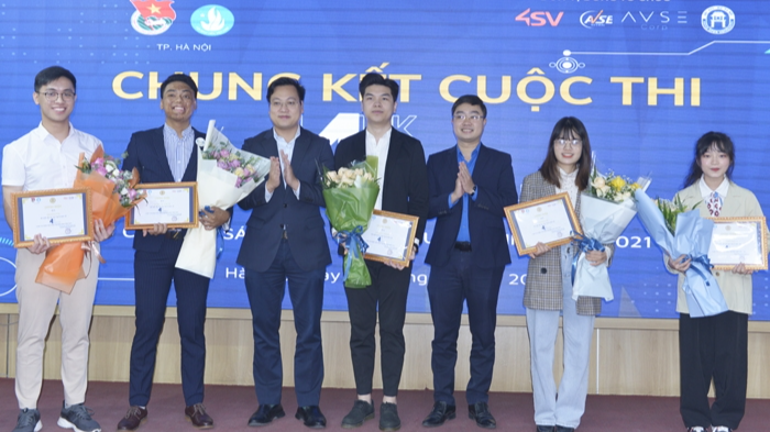 Cao Minh Quân (thứ 2 từ trái sang) đại diện cho các thành viên trong nhóm nhận hoa chúc mừng từ Ban tổ chức cuộc thi