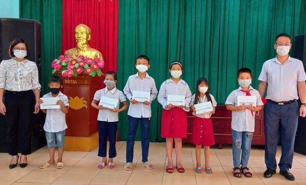 Đ/c Nguyễn Anh Tuấn – Phó Bí thư TT Huyện ủy, Chủ tịch HĐND huyện trao tặng mấy tính bảng cho các em học sinh khó khăn xã Tam Đồng