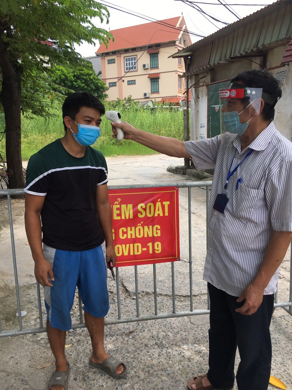 Đo thân nhiệt tại một chốt kiểm dịch, phòng chống dịch Covid-19 tại phường Phương Canh, Nam Từ Liêm