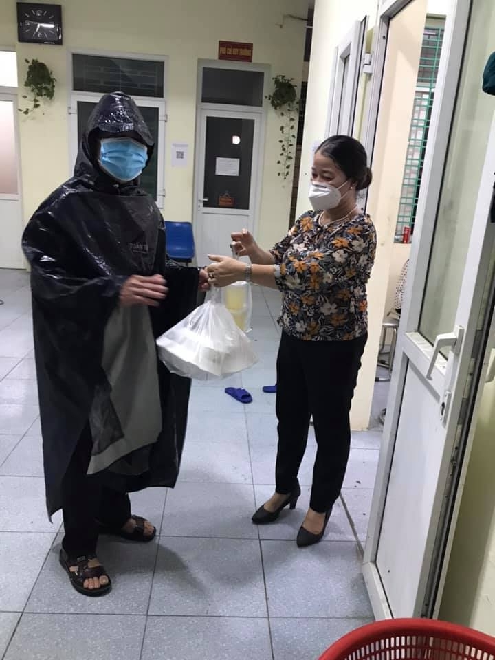 hu Thị Hưng đưa suất cơm cho đồng chí nhân viên y tế làm nhiệm vụ shipper cho bé Hoàng Hương Thảo (2014) và người chăm sóc bé