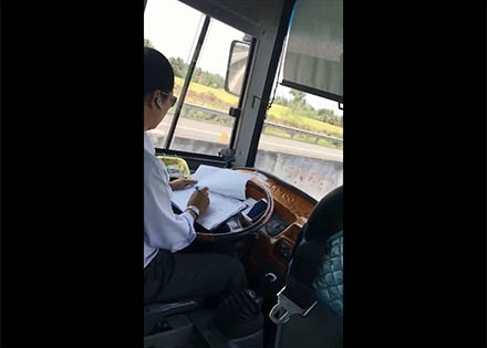 UBATGTQG: Yêu cầu xử lý nghiêm tài xế vừa lái xe vừa ký giấy tờ ở Tiền Giang